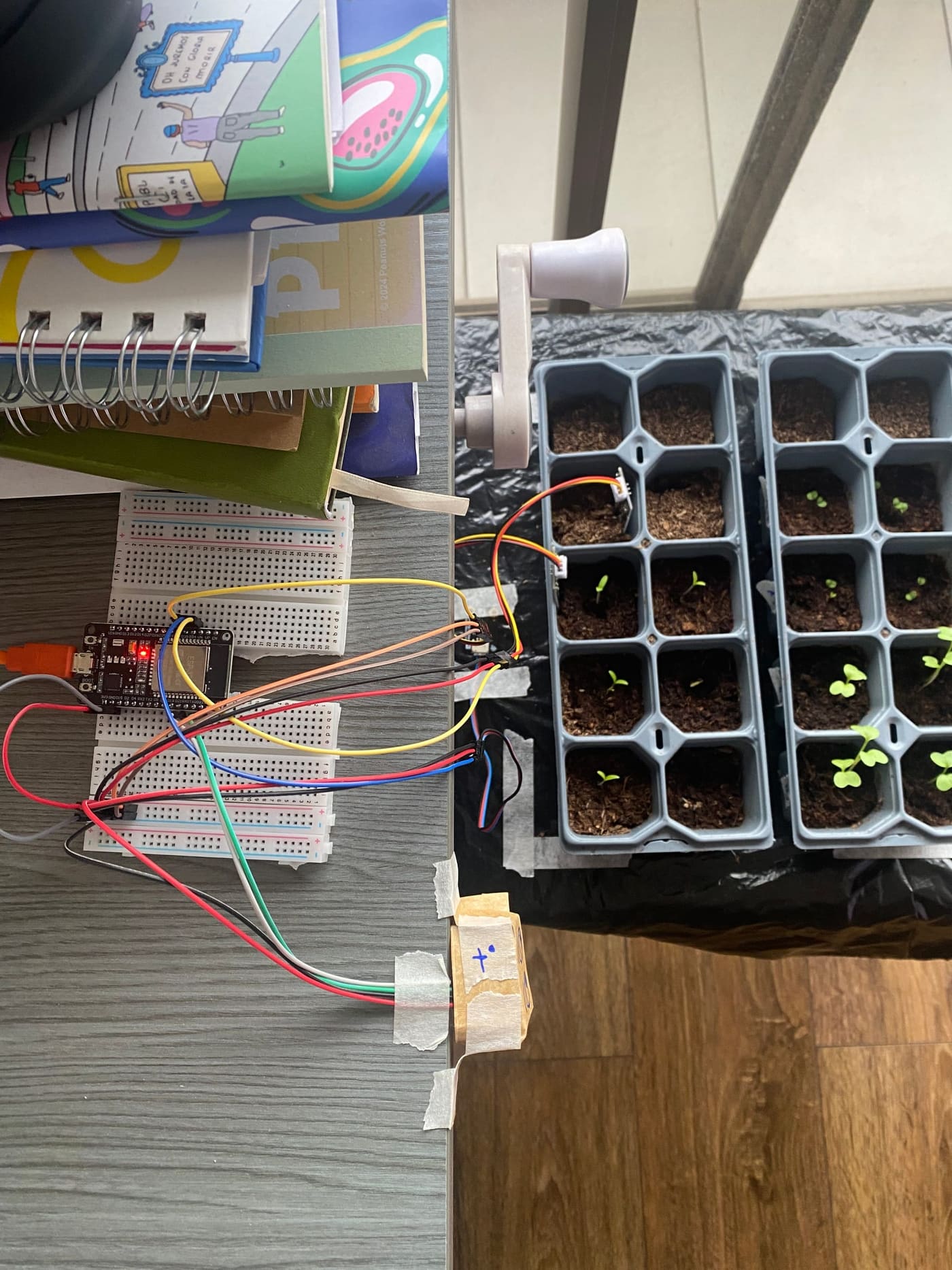 Montaje del nodo vegetal en una protoboard, conectado mediante cables a sensores ubicados junto a las bandejas.